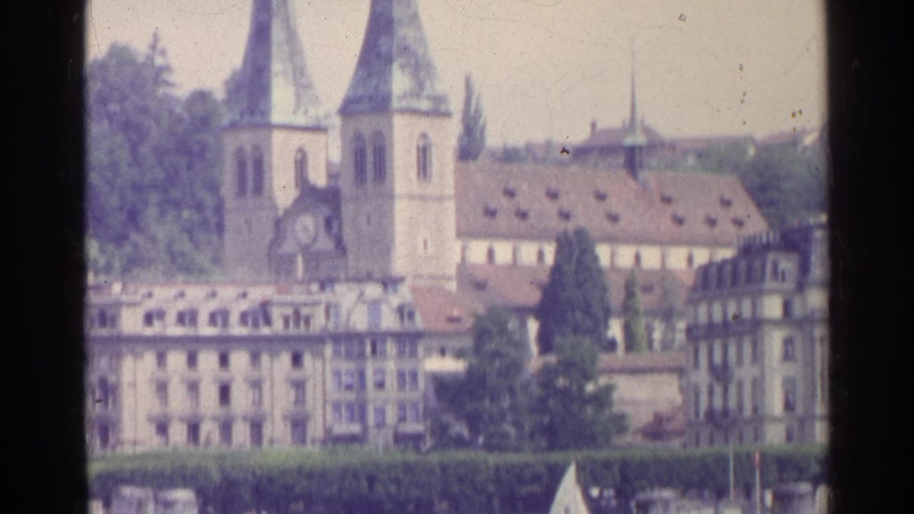 Twin-spired church and lakeside town buildings seen from across the water.