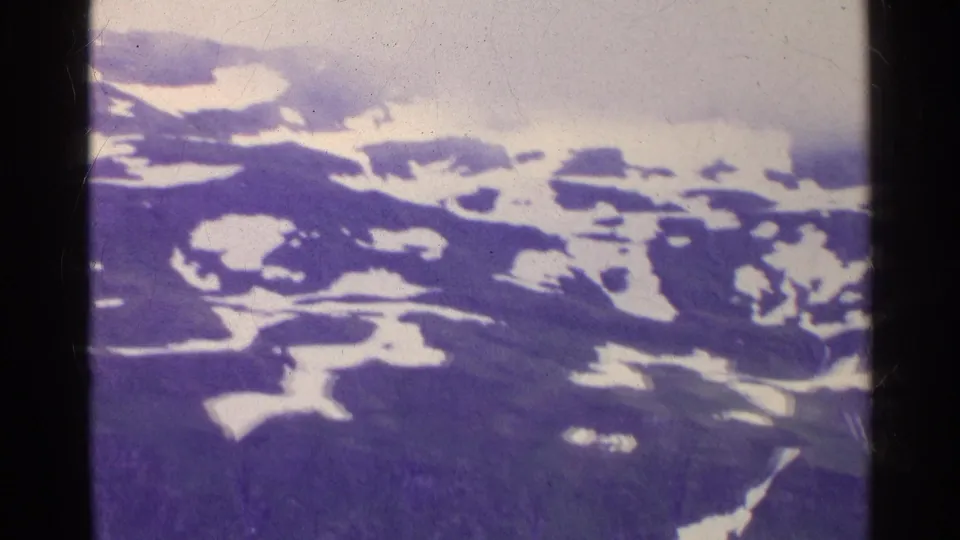 Swiss 8mm travel footage from 1961 showing a snow-marked mountain range softened by mist and color shift.