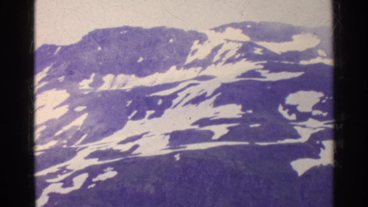 Snowy mountain slope and ridgeline framed by vertical black film borders.