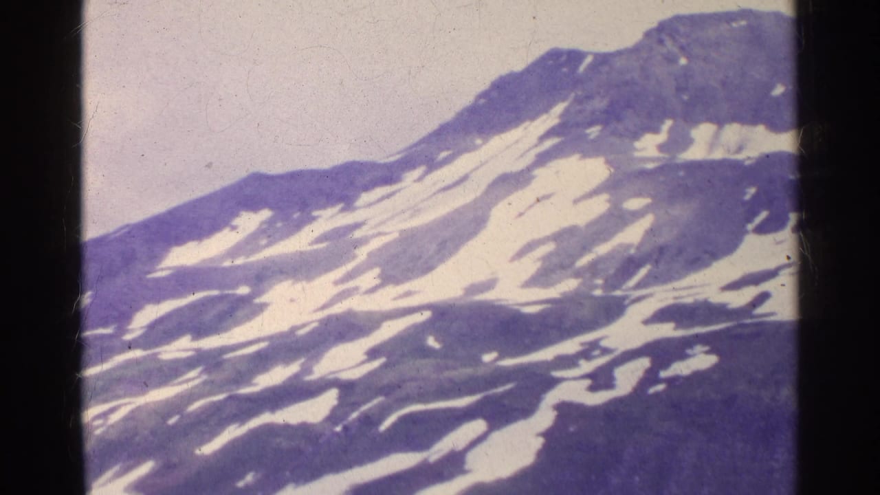 Snow-streaked mountain slope under a pale sky.