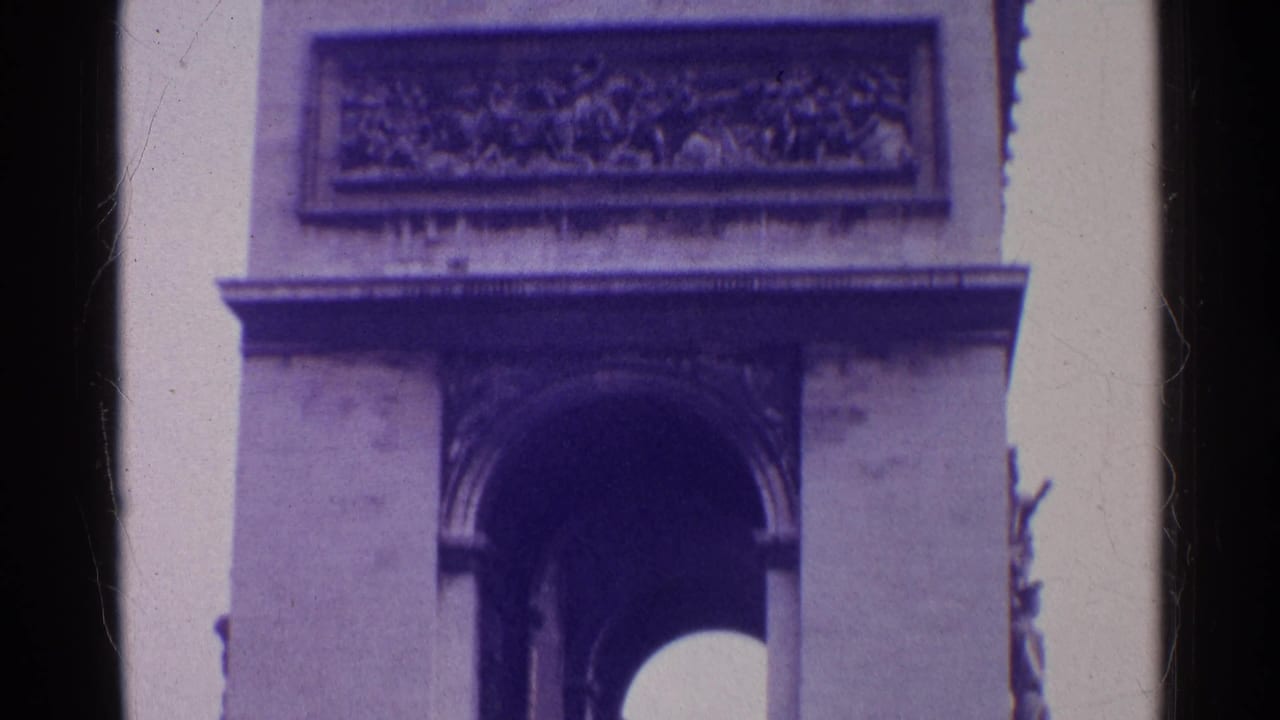 Close side view of a monumental arch with a relief panel and partial sculpture at the edge.