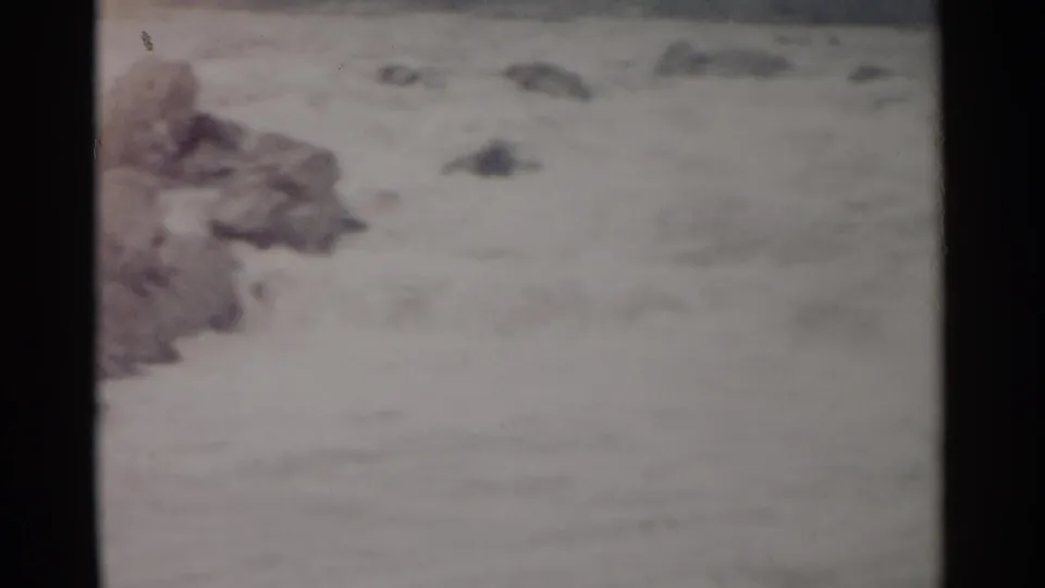 Rushing river water in the Jamestown, Virginia clip, with a rocky edge partly visible and faded 8mm color texture.