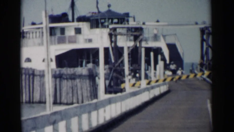 1962 Jamestown, Virginia home-movie frame looking along the pier toward the ferry and vehicle ramp area.