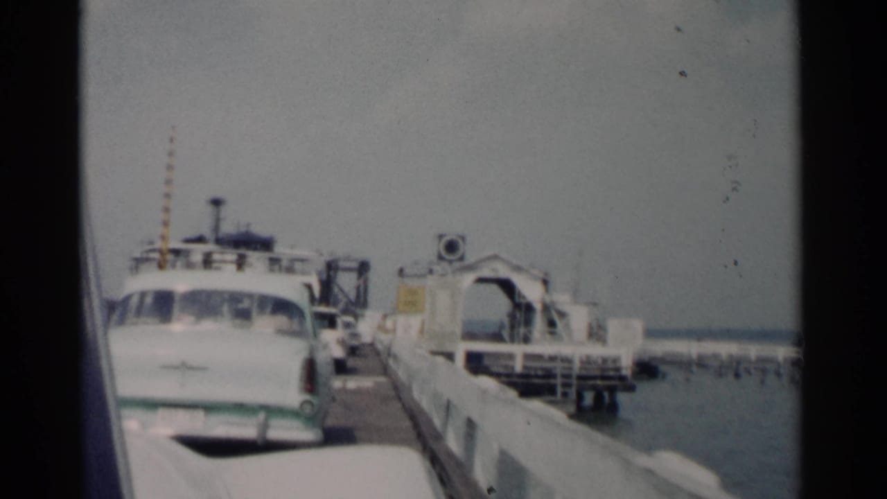 Car and ferry landing seen from a vehicle at the dock.