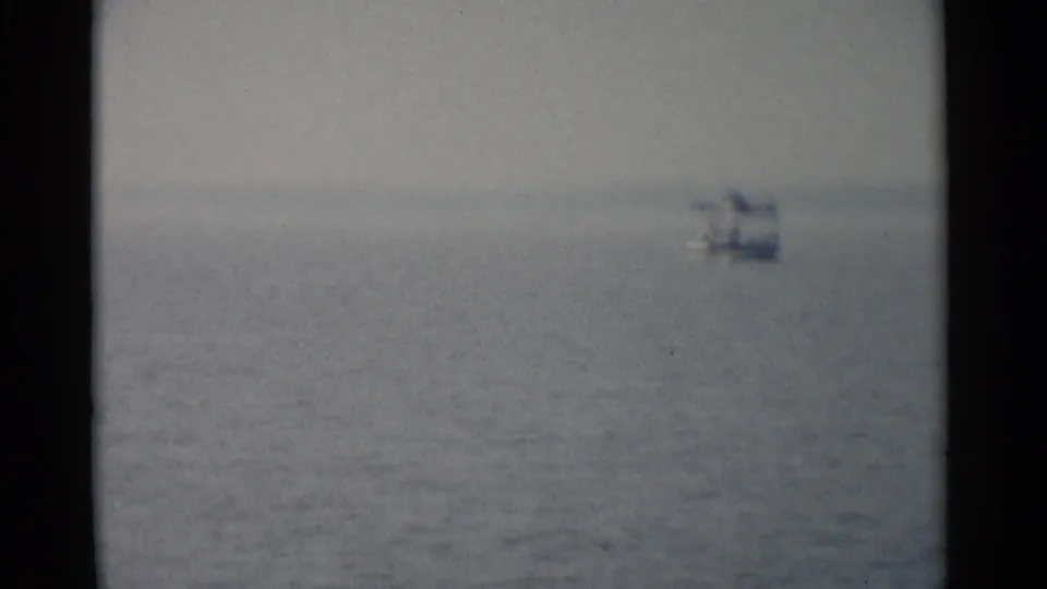 Distant view of a ferry on calm water, closing the 1962 Jamestown travel home-movie sequence.