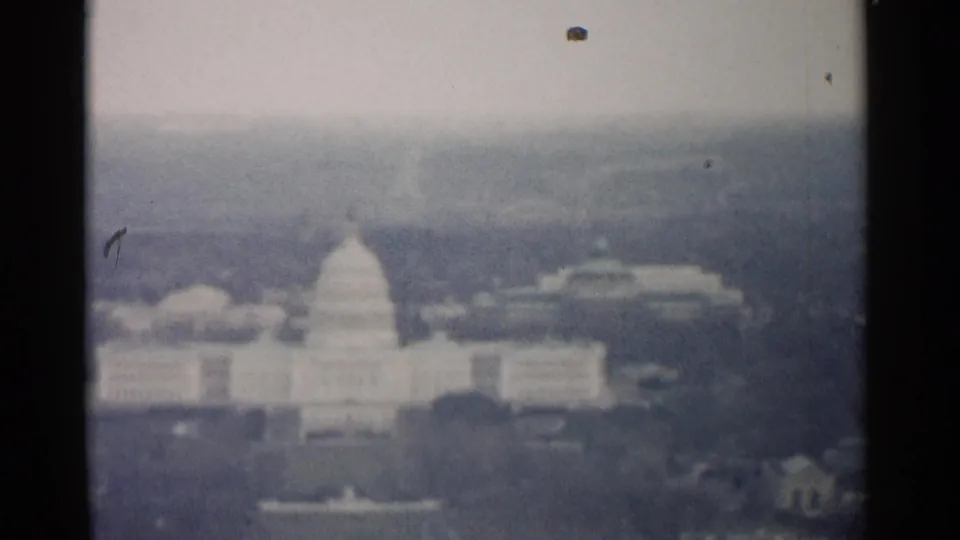 1962 Washington, DC home-movie frame showing a hazy elevated view of the U.S. Capitol dome and nearby buildings.