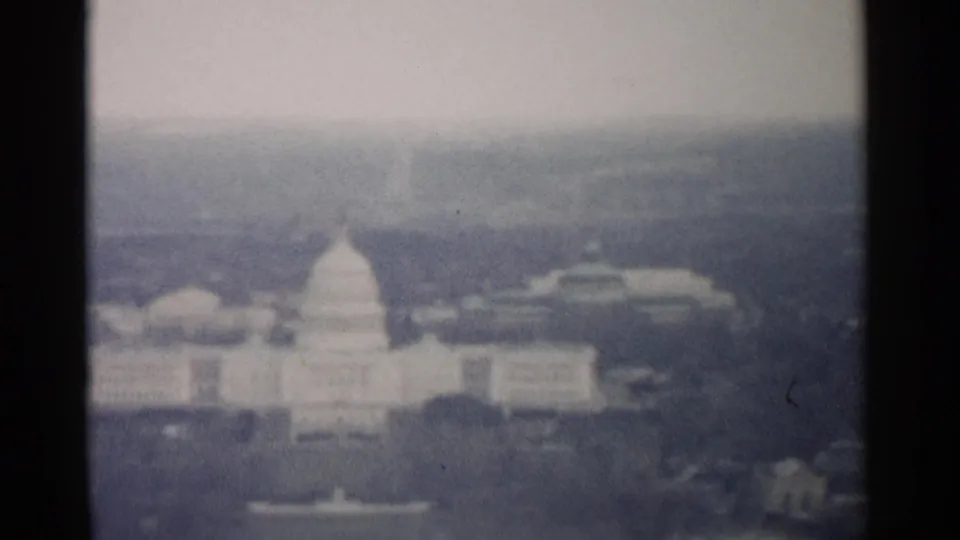 1962 Washington, DC frame with a distant hazy view of the Capitol dome, broad building forms, and muted 8mm color.