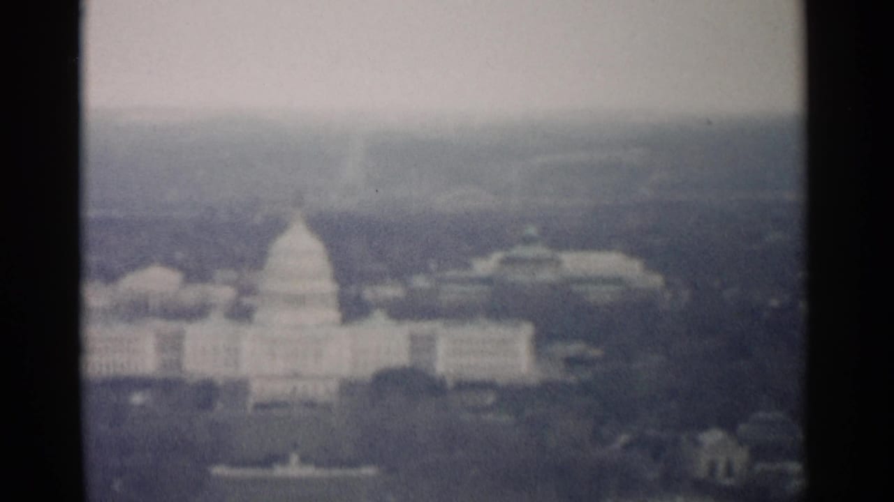 1962 8mm aerial view of the U.S. Capitol in Washington, DC, seen through soft focus and frame-edge shadow.