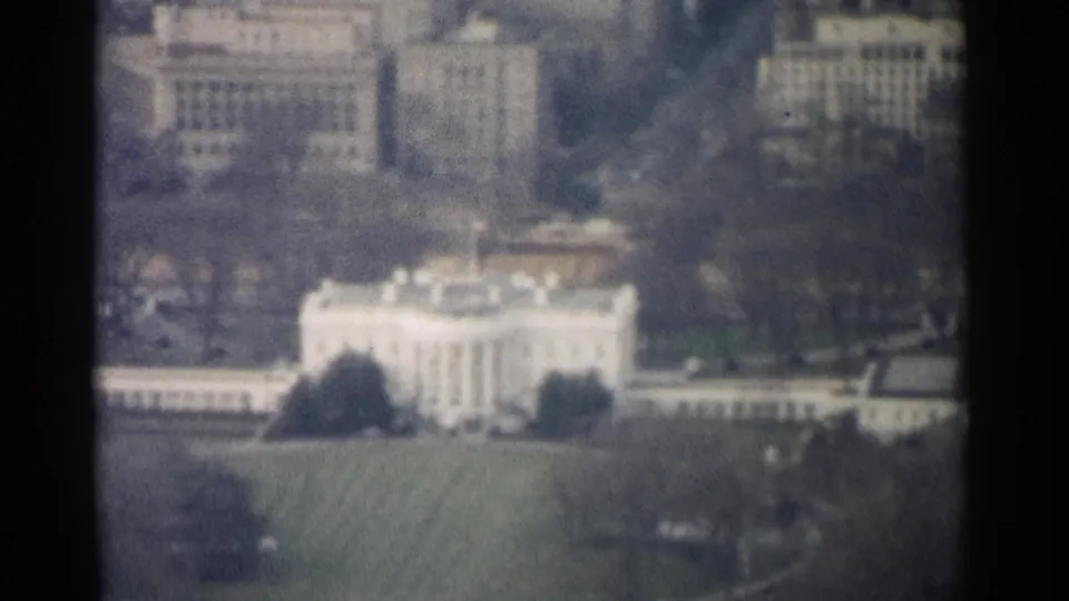 1962 8mm aerial view of the White House grounds, with soft color, grain, and nearby federal buildings visible.