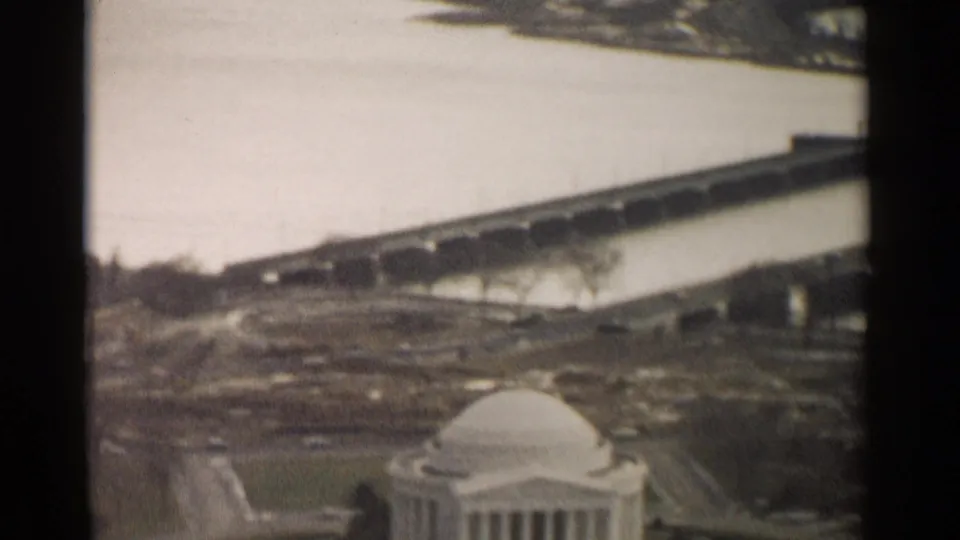 1962 Washington, DC home-movie frame showing the Jefferson Memorial dome below a bridge crossing water.