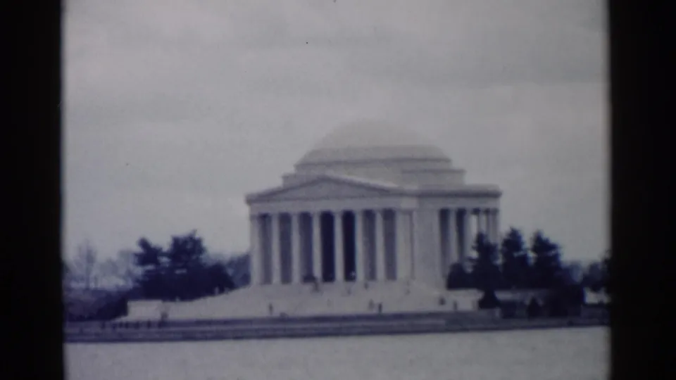 The Jefferson Memorial stands across the Tidal Basin in Washington, DC, with dark trees, pale sky, and soft 8mm focus.