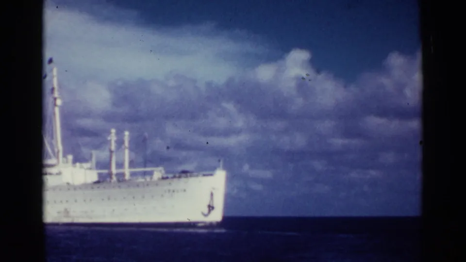 1963 Nassau home-movie frame showing the forward portion of a white passenger liner as the pan carries it toward the edge.