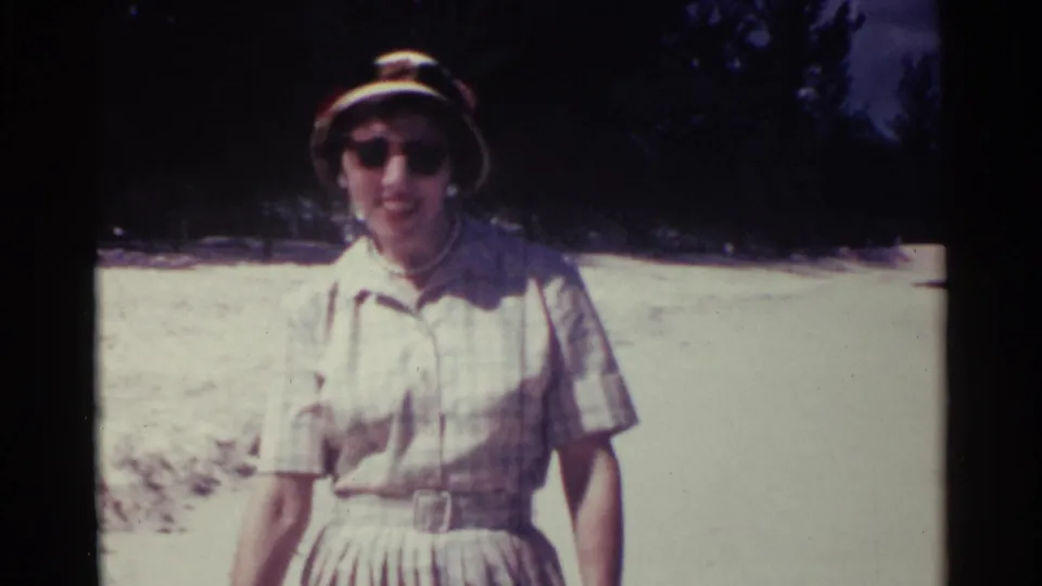 Near the end of the clip, the woman fills more of the frame while standing or walking close to the camera on the Nassau beach.