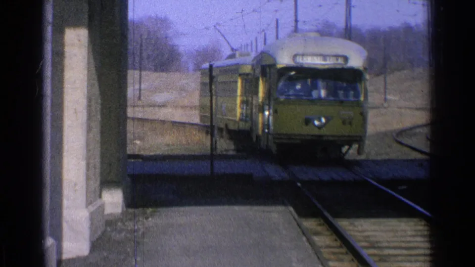 A closer 1965 Ohio view shows the yellow electric train approaching with its front sign and windows visible.