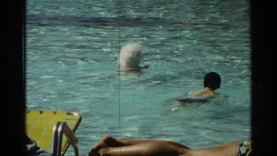 1968 Scottsdale resort pool scene with a swimmer, a water splash, and yellow lounge chairs at the pool edge.