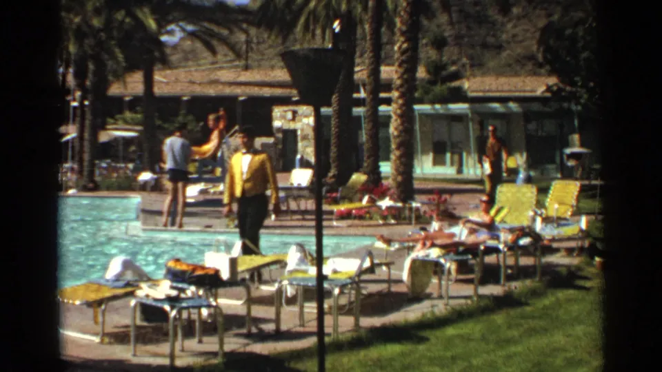 Scottsdale resort pool scene from 1968 showing a man in yellow, seated guests, lounge chairs, palms, and low motel buildings.