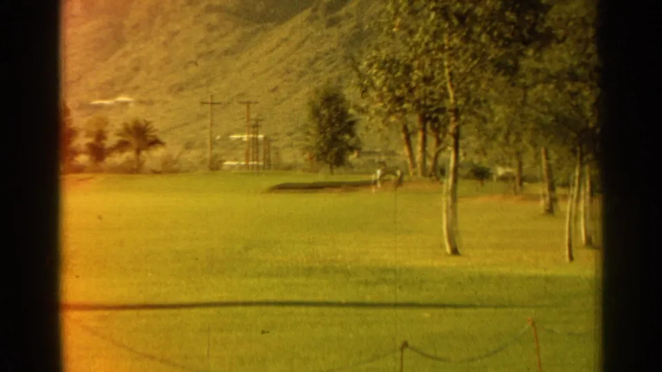 Scottsdale golf-course fairway with palms, utility poles, mountains, and warm 8mm exposure shift.