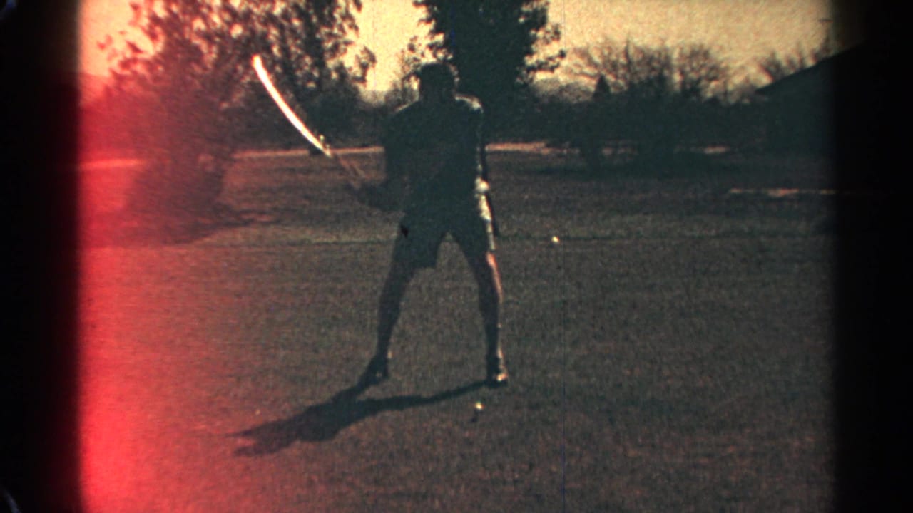 In Scottsdale, Arizona, 1968, a man in white shorts and a blue shirt starts a golf swing on a sunlit course.