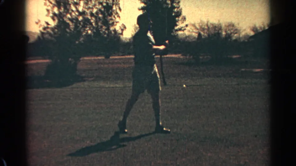 The golfer pauses mid-practice on the Scottsdale course, with trees and low hills visible in grainy 8mm footage from 1968.