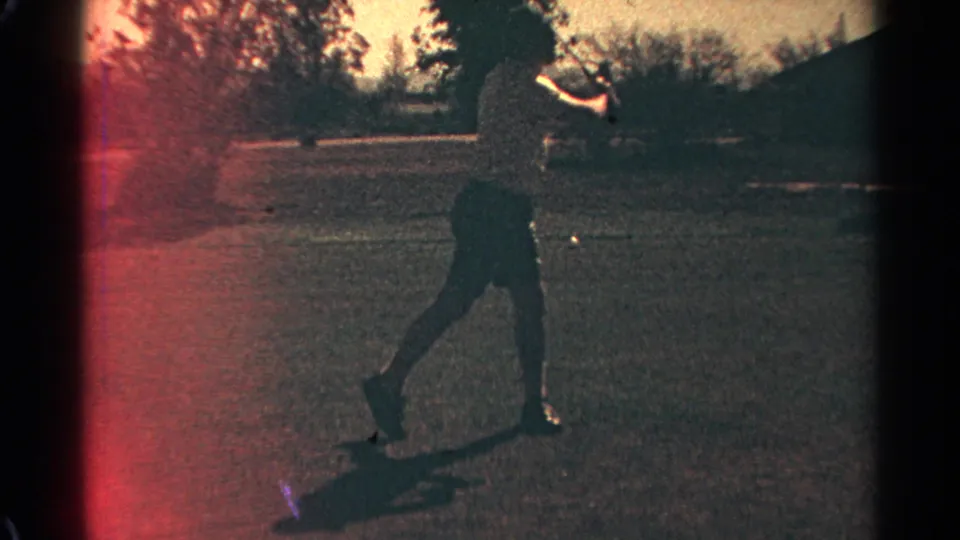 Scottsdale 1968 home-movie frame showing the golfer in follow-through with a small ball visible on the course.