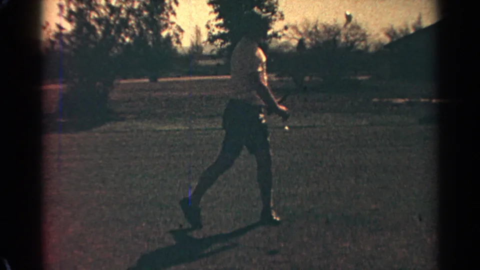 A 1968 Scottsdale 8mm frame shows a man in shorts continuing a golf swing with open course and trees behind him.
