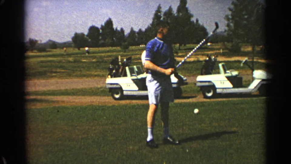 A 1968 Scottsdale home-movie frame shows the golfer resetting or holding his club near the ball on the course.