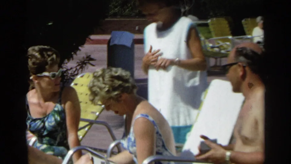 Adults gather by Scottsdale poolside lounge chairs, with a seated woman in sunglasses and a shirtless man at right.