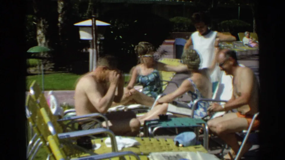 Poolside 1968 Scottsdale frame with a seated man leaning forward and adults relaxing on metal lounge chairs.