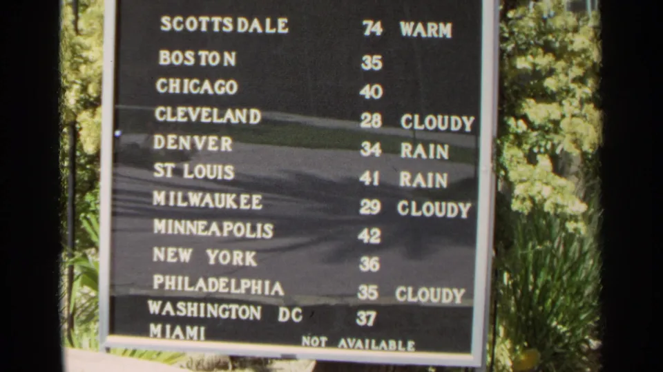 1968 Scottsdale weather board showing city names, temperatures, and conditions beside bright outdoor foliage.