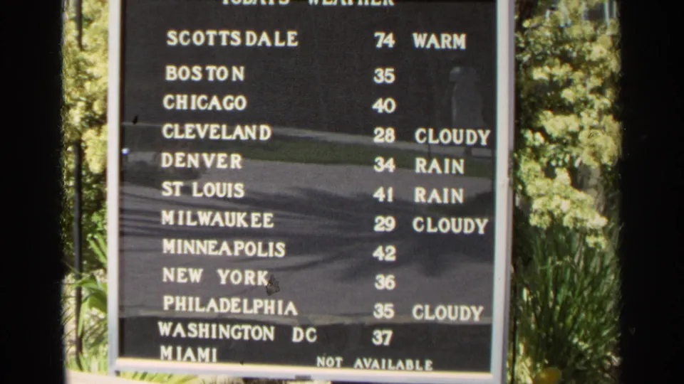 1968 Scottsdale frame of a public weather board listing multiple U.S. cities, temperatures, and conditions including cloudy and rain.