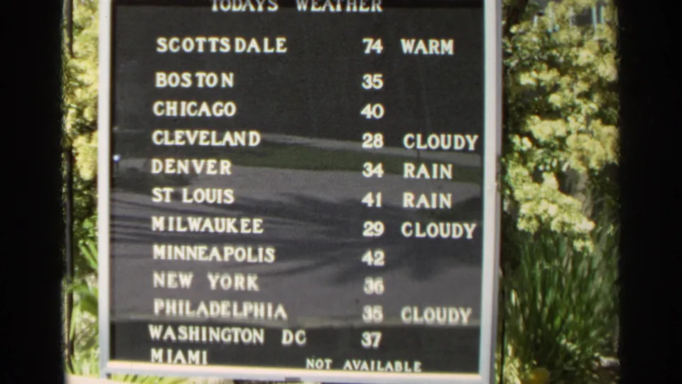 1968 Scottsdale frame of an outdoor weather board with city names, temperatures, and weather notes framed by greenery.