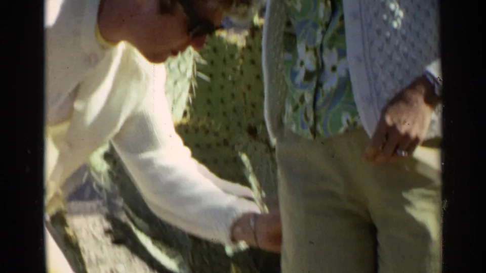 A close handheld view shows two women beside cactus pads in the 1968 Scottsdale home-movie footage.