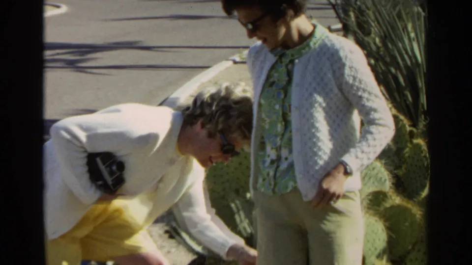 A wider 1968 Scottsdale frame shows two women near cactus plants, one bent forward and one standing in bright desert light.