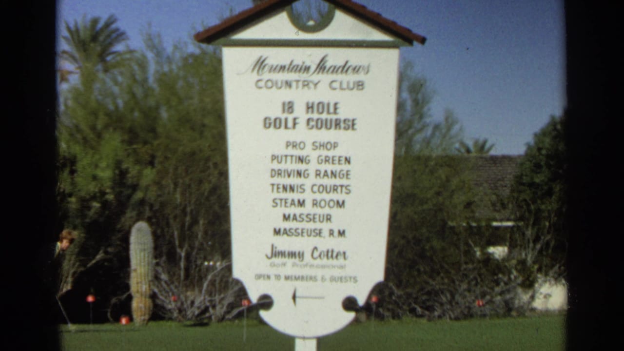 1968 Scottsdale footage showing the Mountain Shadows Country Club sign listing golf course and club amenities amid lawn, trees, and desert landscaping.