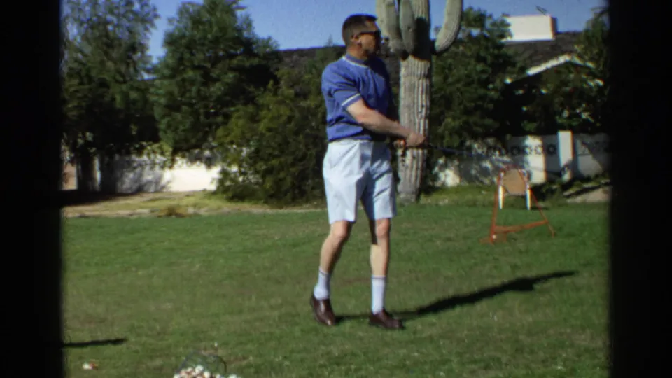 The 1968 Scottsdale 8mm frame shows a man on a sunny lawn holding a golf club, with a saguaro cactus and garden wall behind him.