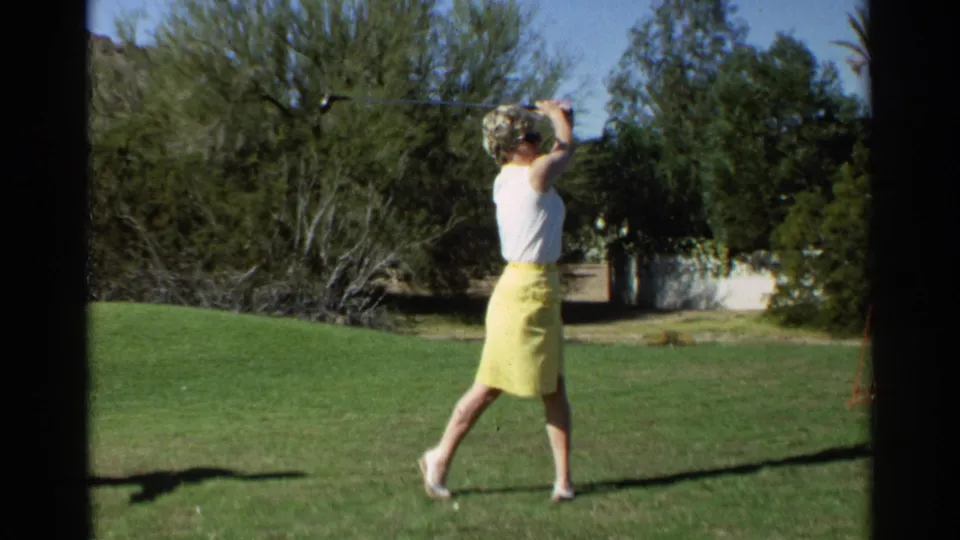 A 1968 Scottsdale frame shows the golfer turned sideways with her club overhead during the follow-through on a green lawn.