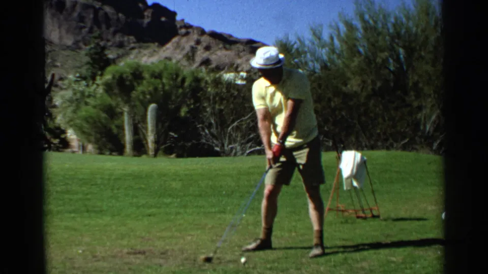 At the end of the clip, the golfer stands near the ball on the Scottsdale fairway, framed by cacti, shrubs, and hills.