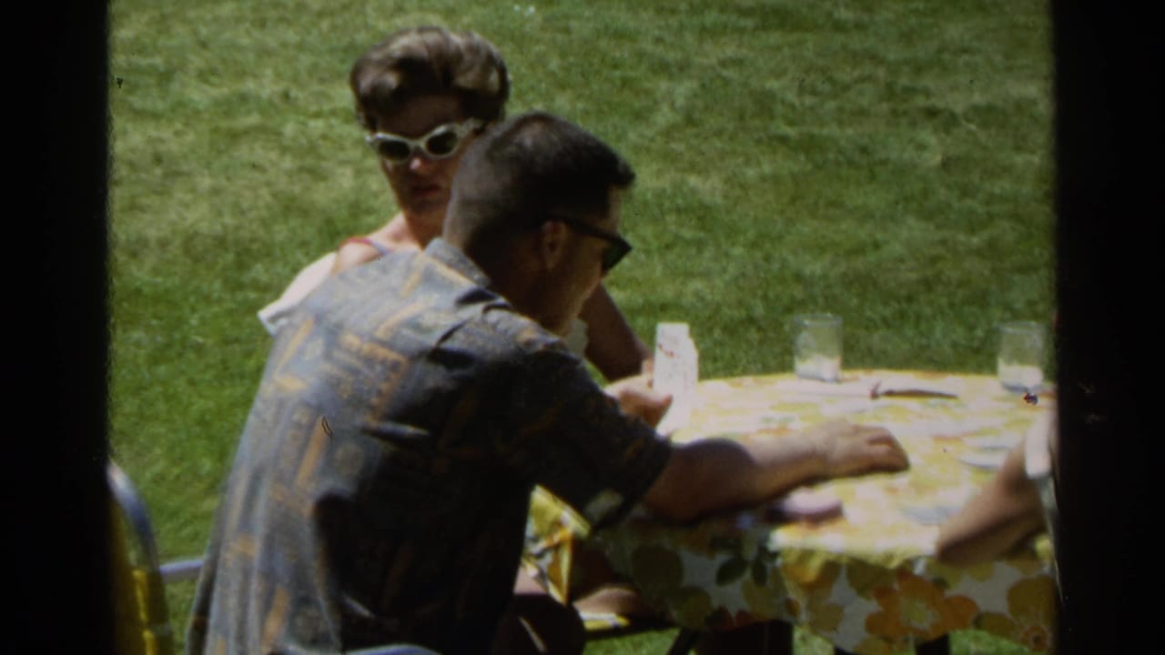 A closer 8mm view shows adults at the Scottsdale backyard table, with a woman in white sunglasses facing the camera.