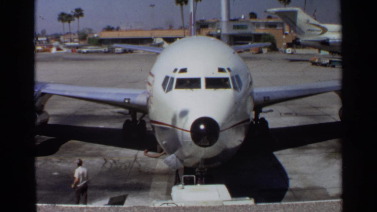 Front view of a parked Western Airlines jet with a ground worker on the tarmac.