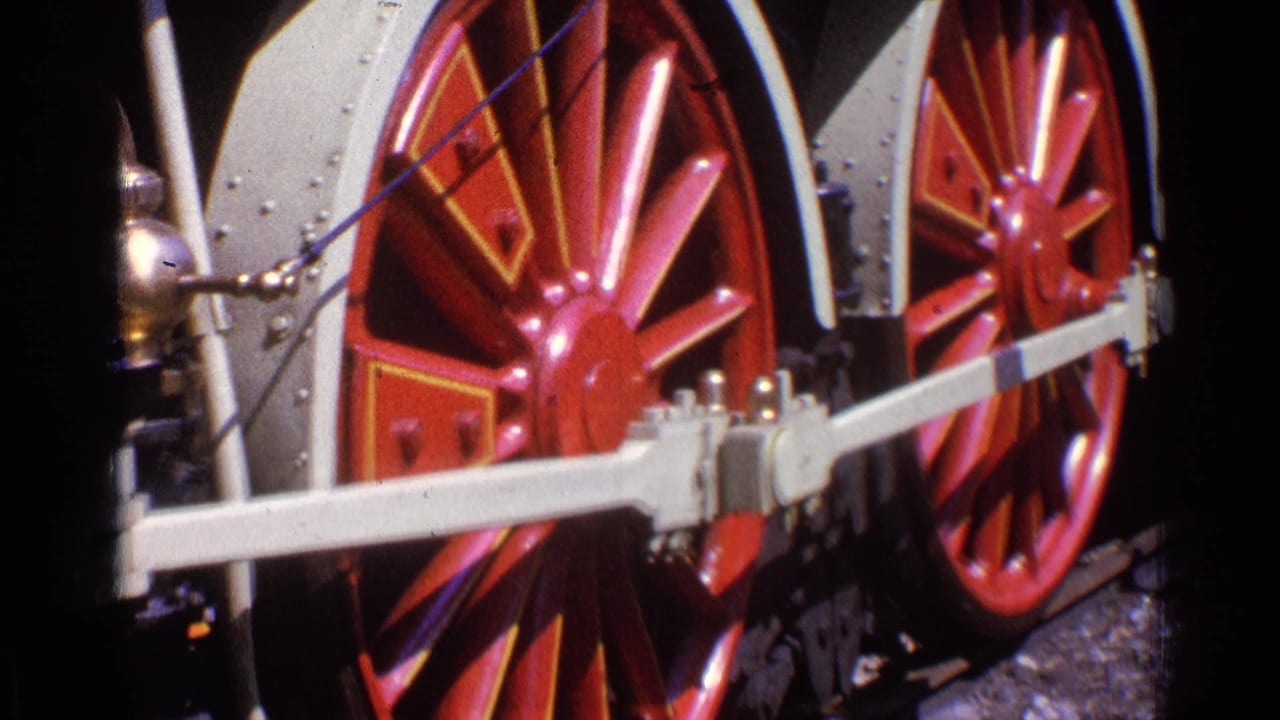 Close-up of red steam locomotive driving wheels and connecting rods in 1976 Chicago archival 8mm footage.