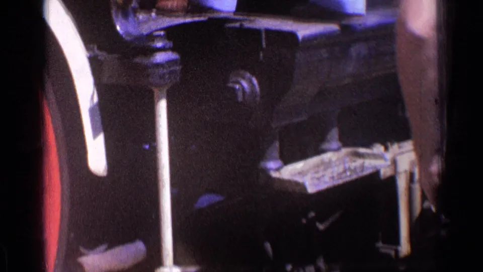 Shadowed close-up of locomotive undercarriage hardware and fittings from Chicago 1976 home-movie footage.