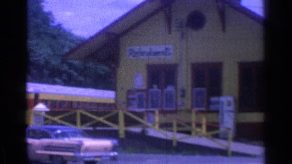 Yellow station-style museum building in Chicago with visible train cars, access ramp, and a period automobile in 1976 8mm footage.