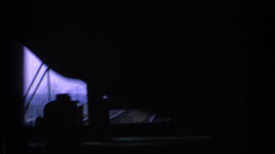 From inside a moving Chicago train in 1976, the window frames tracks, wires, and a steel rail structure outside.