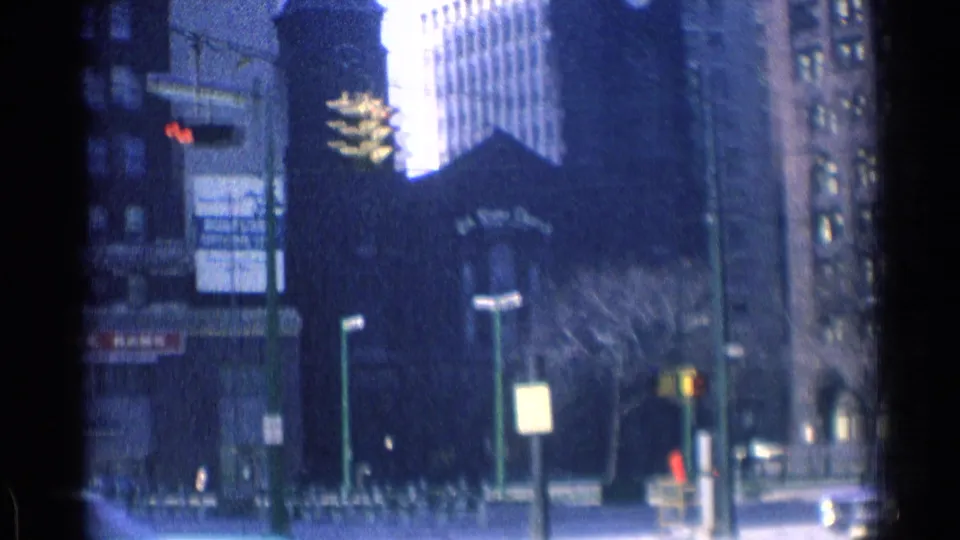Chicago street view with a dark church-like entrance, surrounding high-rises, traffic lights, signs, and distant pedestrians.