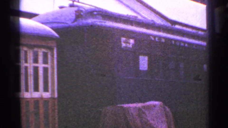 Brick station building in Connecticut with bay window, station signage, and partial lettering near the roofline.