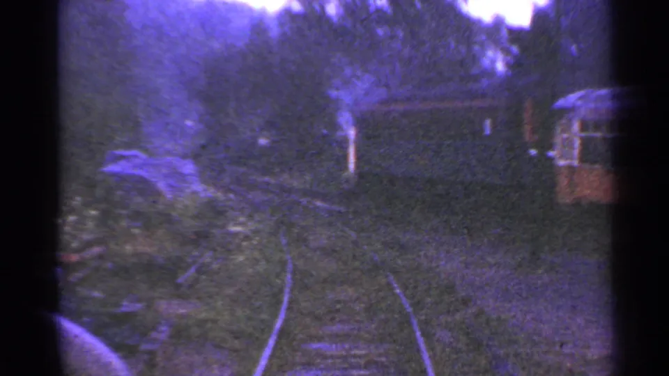 1953 Connecticut rail corridor view showing curved tracks, trees, a path, and small rail vehicles or cars.