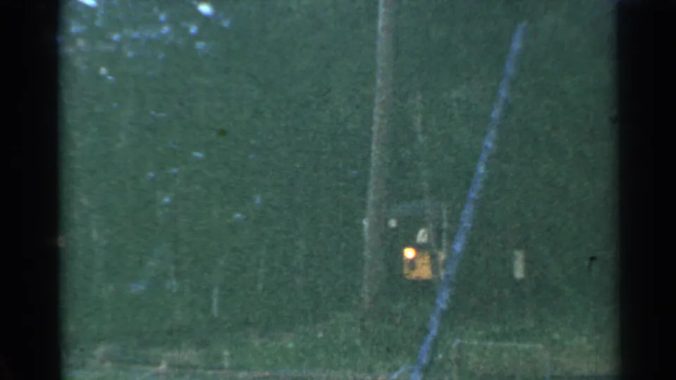 Final 1953 Connecticut rail-travel frame with green color shift, faint trackside vegetation, vertical gate edge, and a small point of light.