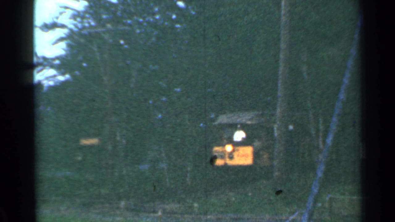 The small tourist train moves closer through the Connecticut woods, its headlight visible in the faded 8mm frame.