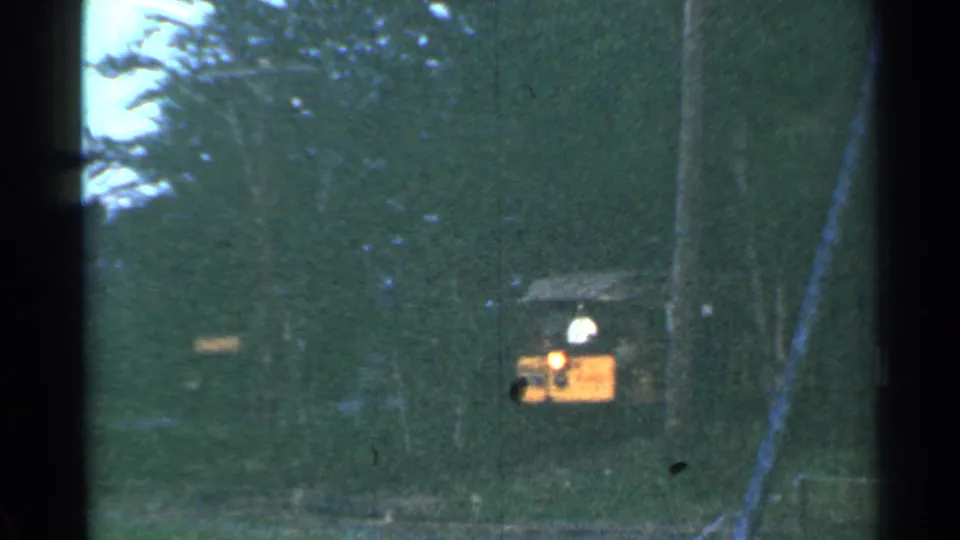 The small tourist train moves closer through the Connecticut woods, its headlight visible in the faded 8mm frame.