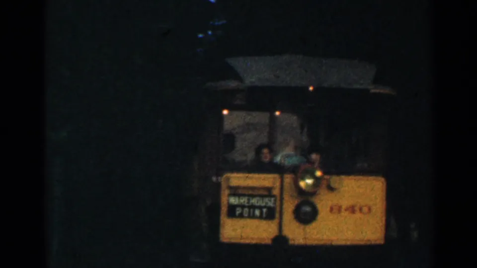 1953 Connecticut 8mm frame showing a yellow trolley at a dark tunnel entrance with its WAREHOUSE POINT sign and headlamp visible.